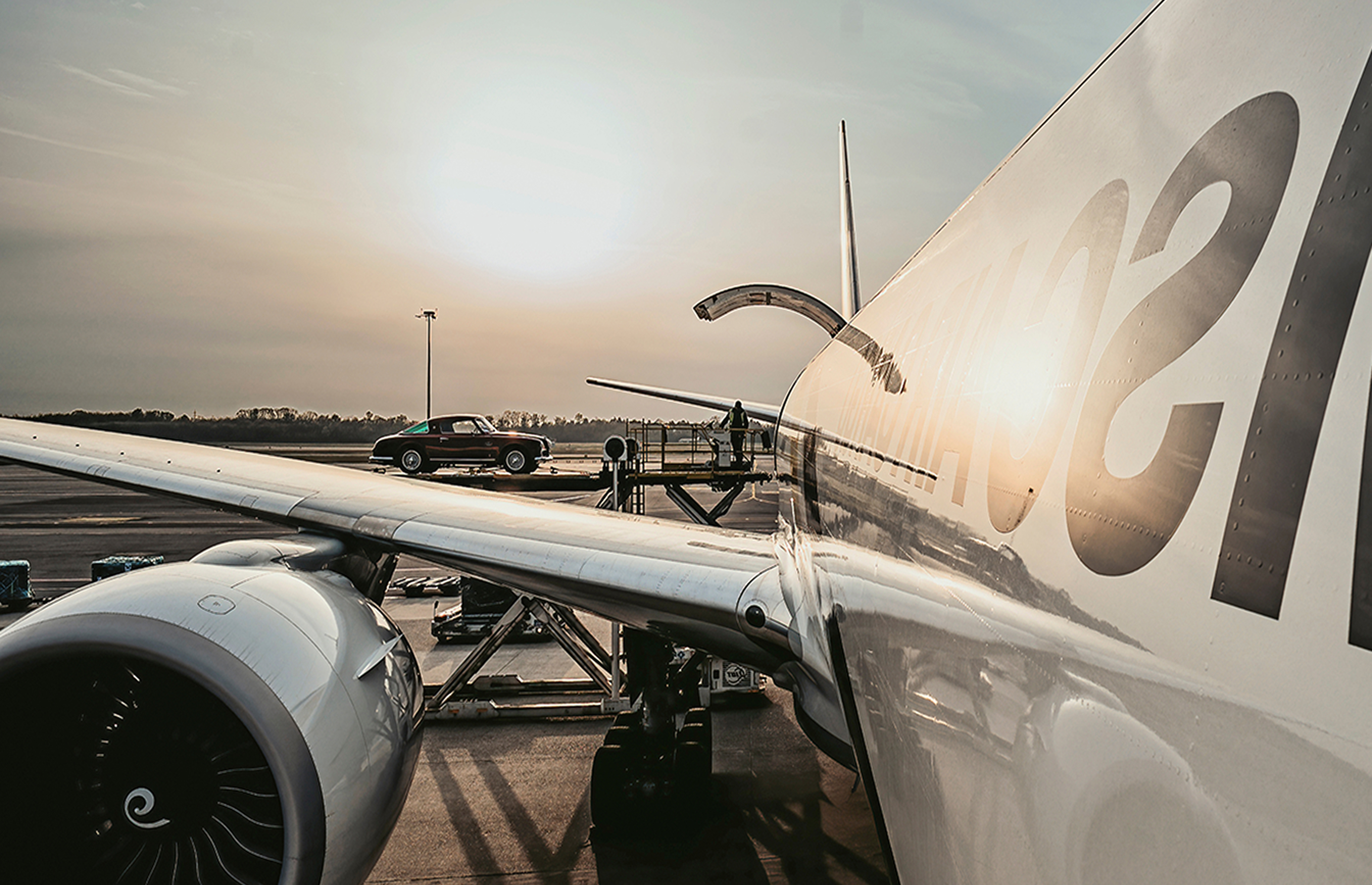 Rare luxury car being carefully loaded into MSC Air Cargo aircraft through open cargo door for customized air freight shipping service