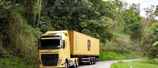 Yellow truck carrying a MSC dry container