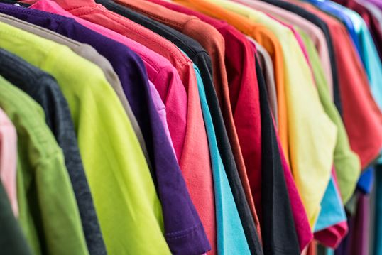 Brightly coloured garments on a clothes rack, showcasing MSC’s end‑to‑end shipping services for retail and apparel.