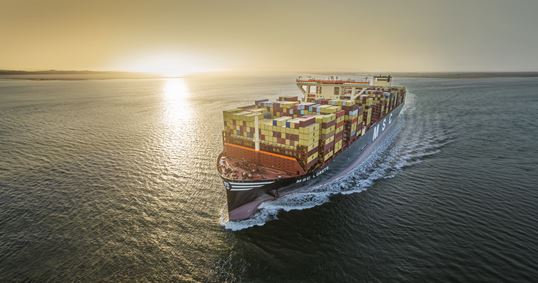 MSC container vessel sailing along the coast at sunset, representing MSC’s reliable short sea shipping network.