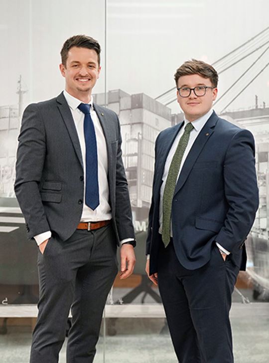 Professionals in business attire standing in an office, representing MSC’s Far East import trade management.